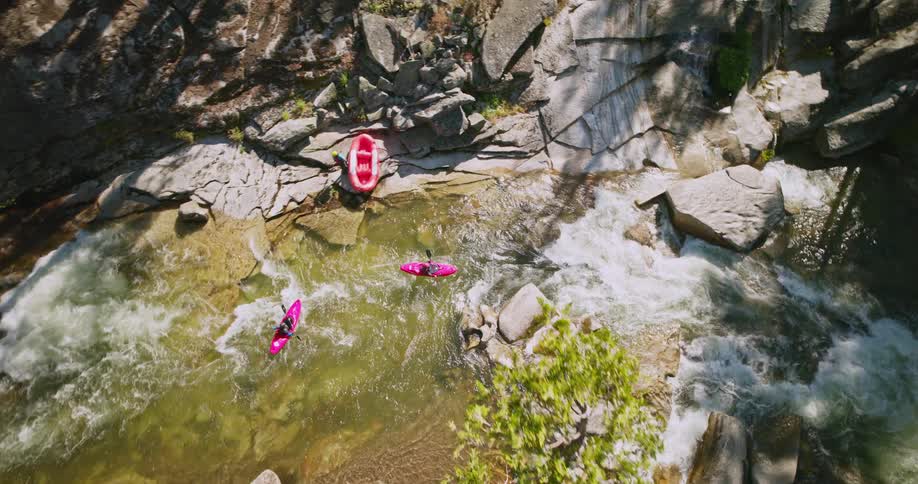 People are kayaking in the rapids