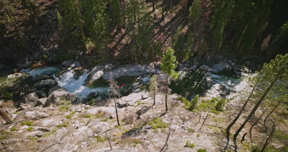 Landscape of a river in the middle of the forest in the mountains with two people canoeing