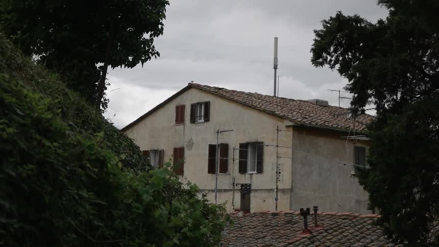 A bird flies and lands on a terra cotta roof