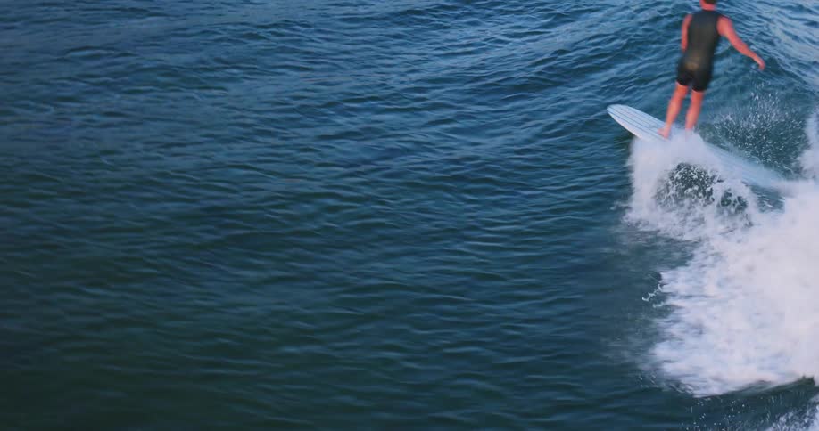 A surfer riding a wave while avoiding other surfers in his way