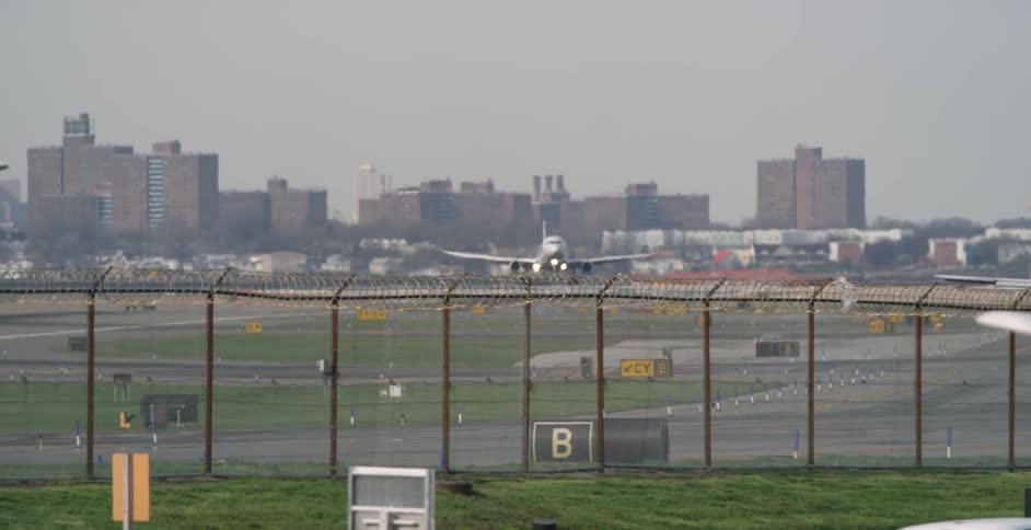 An airplane getting ready to land on the runway near a city