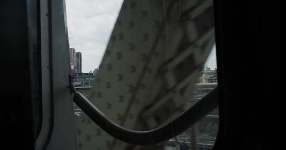 A train travels down a bridge near a city