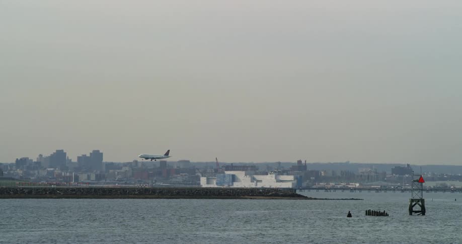 A plane lands near a body of water