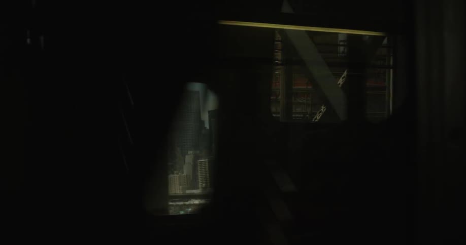 A commuter train is passing over a bridge outside a large city