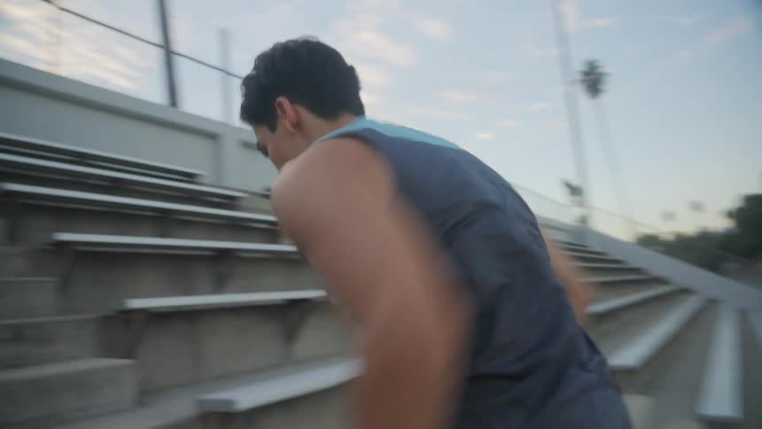 Man quickly climbing the stairs of a stadium performing cardio