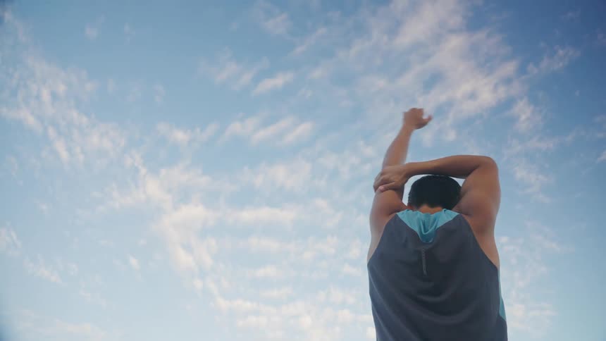 A male stretches outdoors
