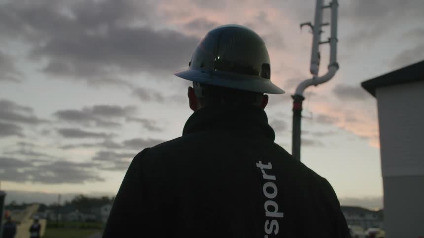 A construction worker watching the sky during dusk