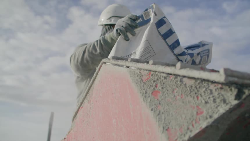 Man putting bag of cement inside a storage