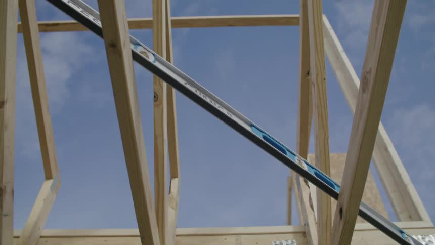 Construction level resting across two by fours on an unfinished building frame during the day