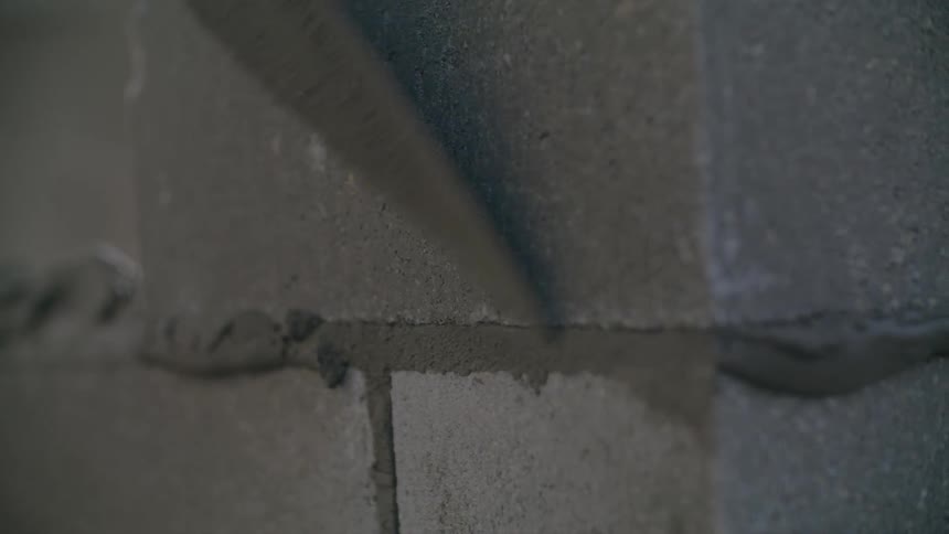 A person is building a wall with blocks