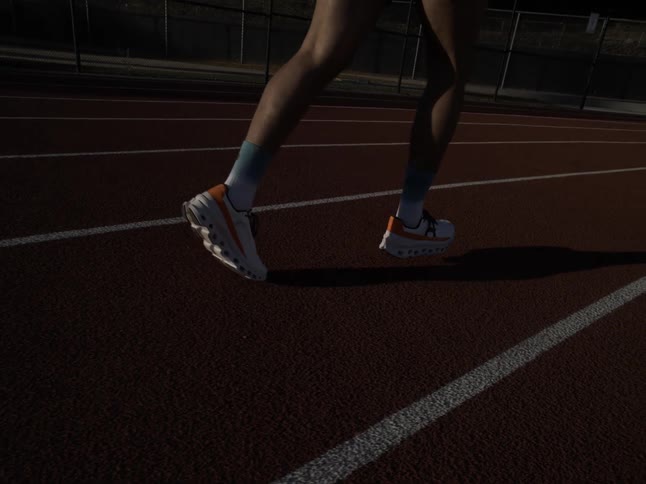 A person running on an athletics track on a sunny morning