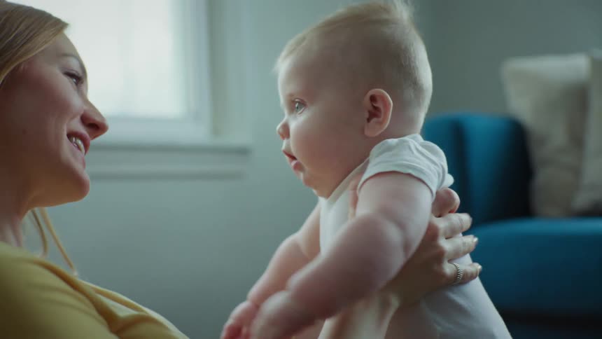Mother holding her son in her arms as he smiles