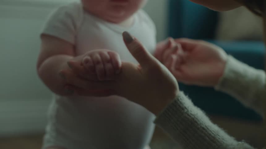 A mother holds her sons hands