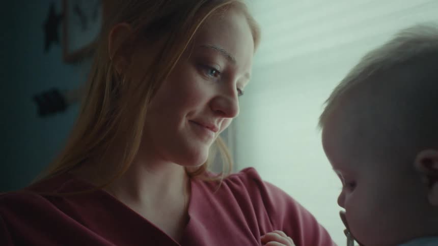 Portrait of mother holding her baby on her lap with happy facial expression