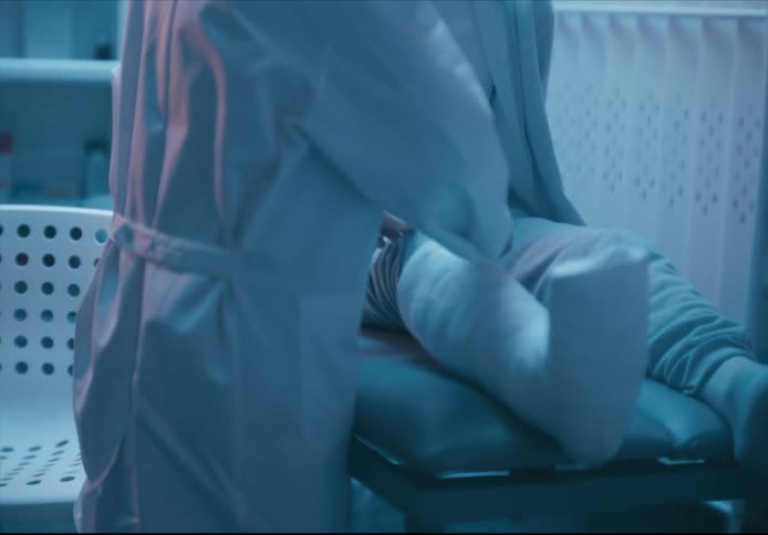 Closeup on a persons legs fully bandaged as a doctor watches