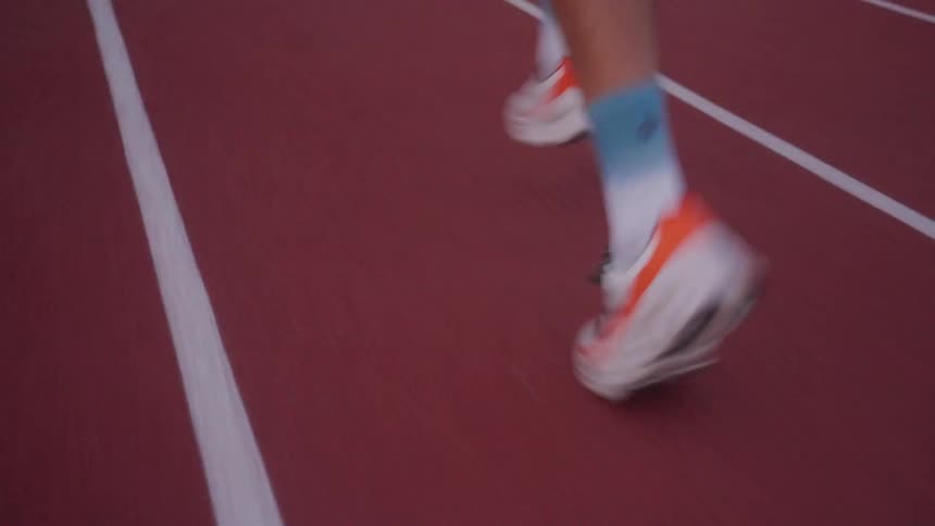 Closeup of a persons feet running on an athletics track