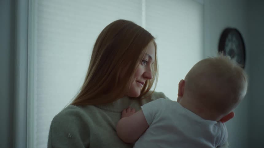 Closeup of the face of a caring mother holding her baby in her arms