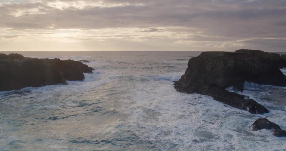 Landscape of rocks in the middle of the sea with the sun on the morning horizon