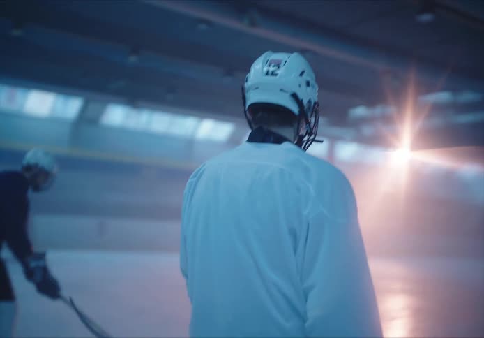 Man skating and with equipment on a hockey court