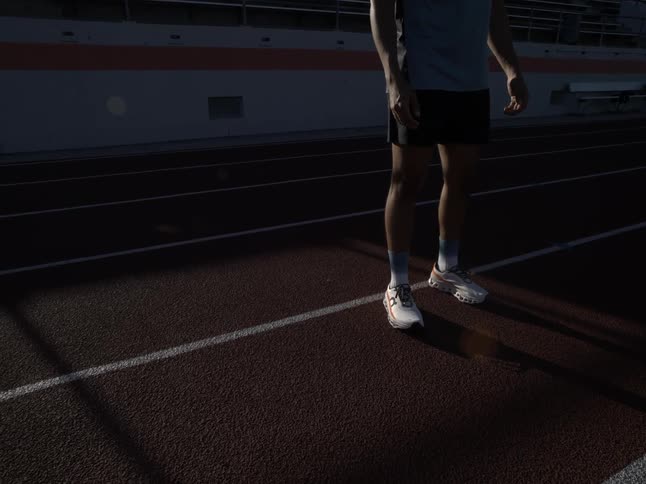 A man in shorts stands on a race track