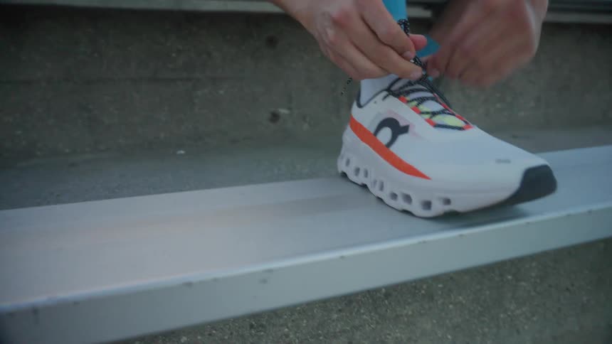 Closeup of a man tying his sneaker laces while sitting in the stands