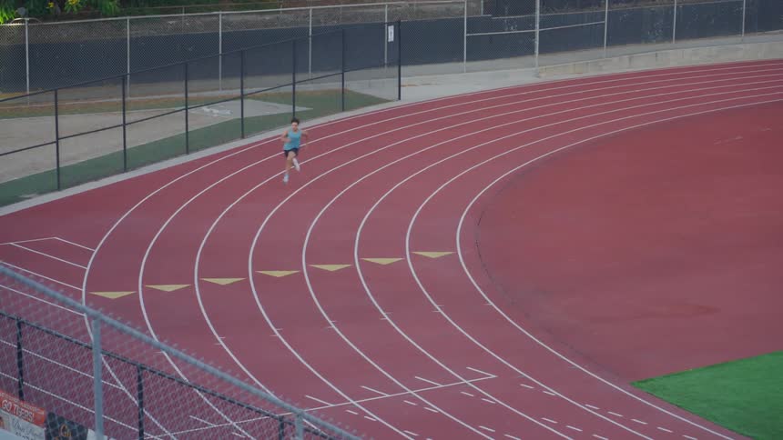 Latino athlete sprinting around an outdoor track