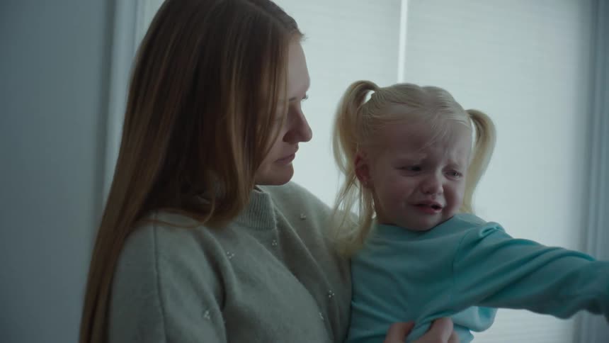 A mother reassures her crying daughter