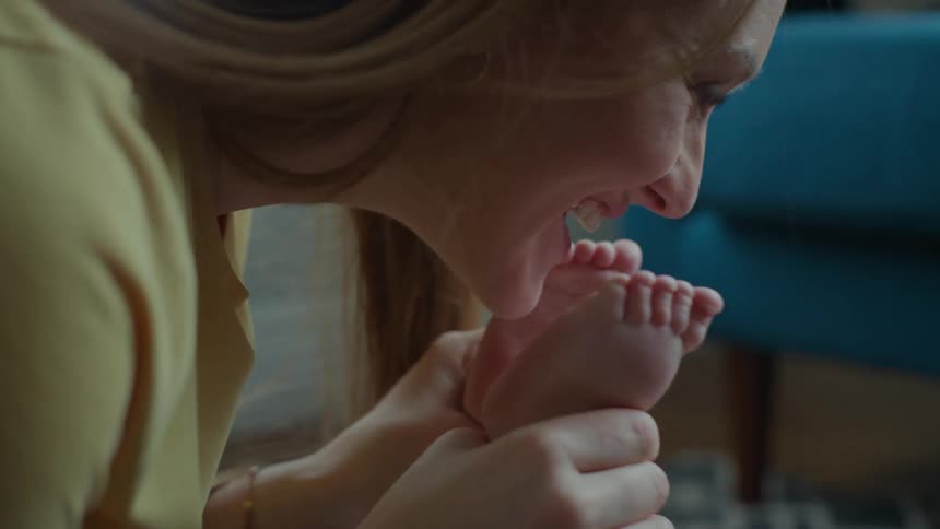 Mother playing with the foot of her son
