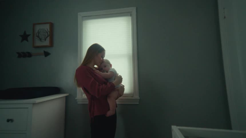 Mother holding her baby affectionately inside a room