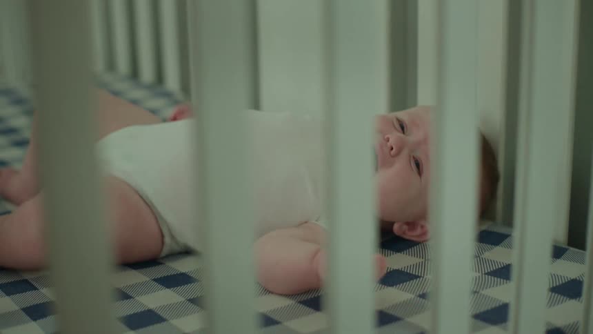 Baby lying in crib crying
