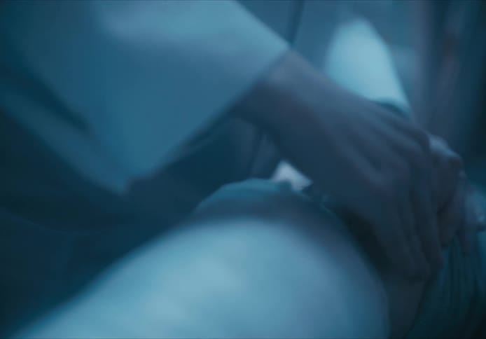 A hand of someone who is caring for a person sitting with an injured knee