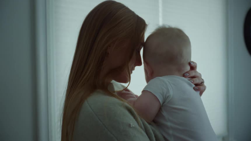 A mother is holding her baby