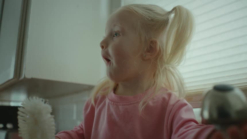 Closeup of a girls face working with a tap at home