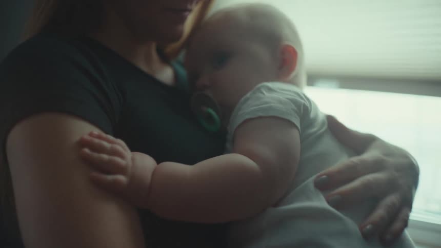 A mother hugs her baby as she puts him to sleep