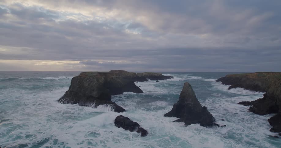 Sea waves breaking in a coastal region with huge rocks in the water