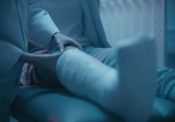 A doctor examines a patient with a leg in a cast