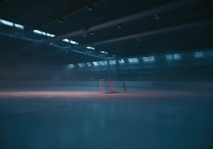 A hockey player skates around a net