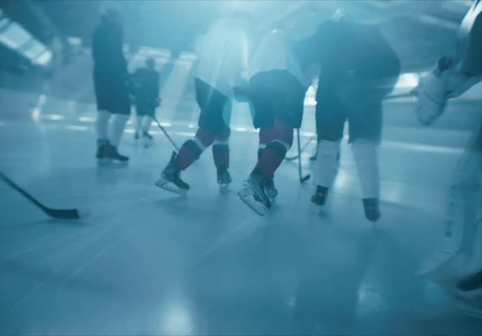 Some people holding another person and walking on the ice and everyone is wearing hockey equipment