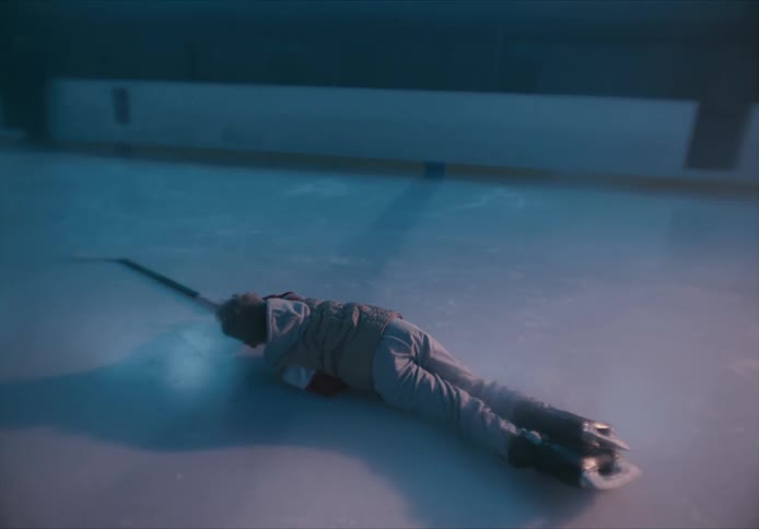 Boy on a hockey court falling to the ground