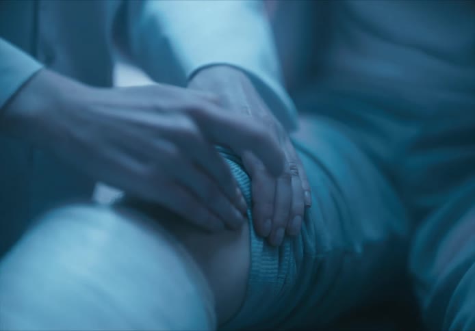 Closeup of a doctors hands examining a persons knee