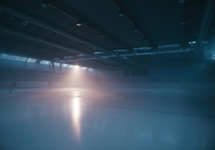 A person skates around an indoor ice rink