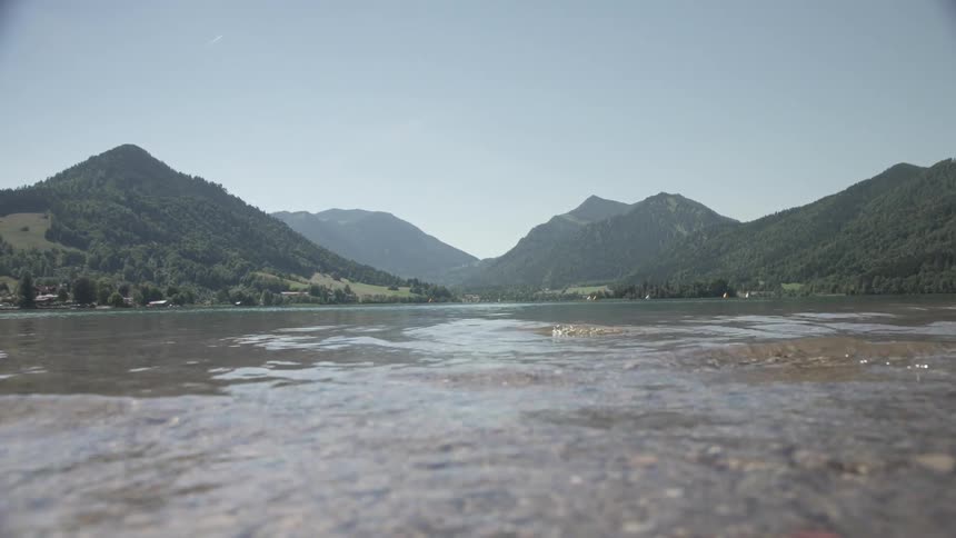 Seaside surrounded by green mountains during sunny day