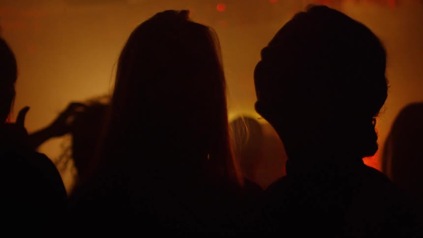 Silhouette of a couple watching a live show on a stage