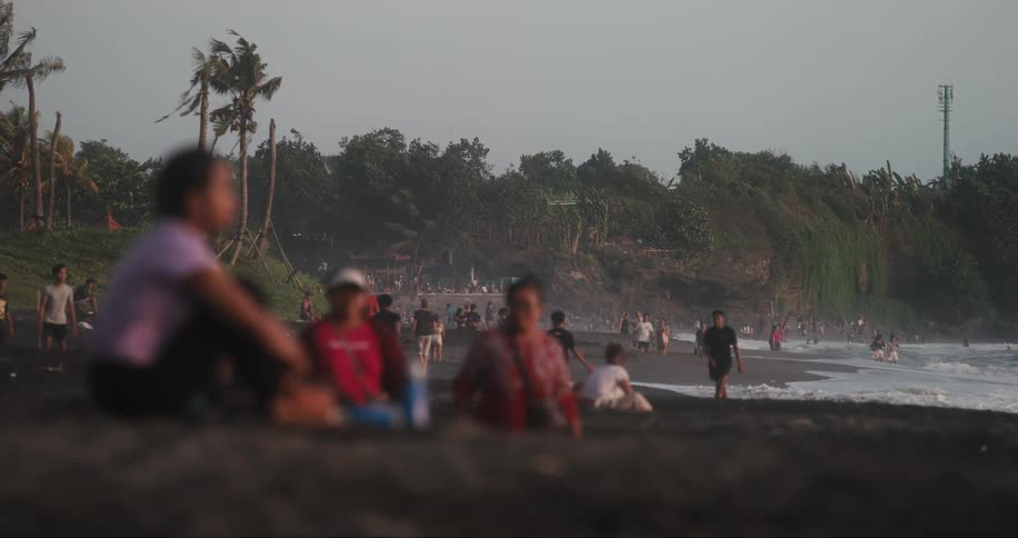 Crowds of people populate a beach