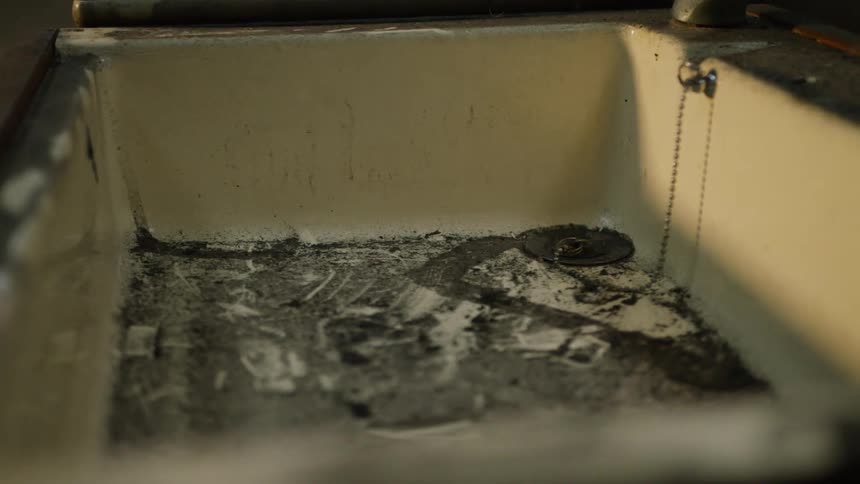 Closeup of a dirty sink with sun glare