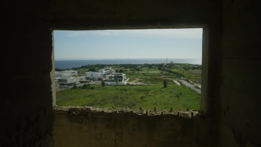 An island is seen from the window of an old building