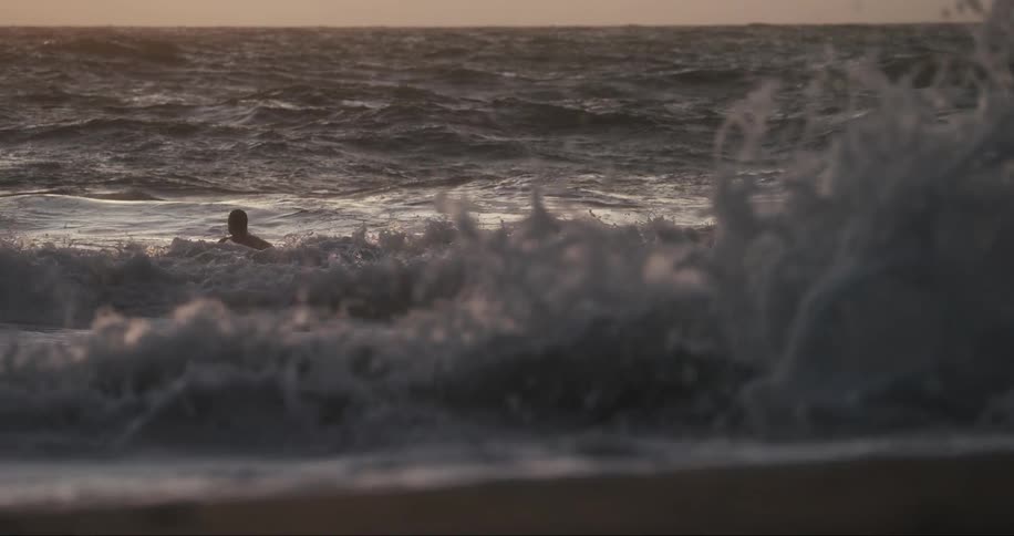 Man diving into a wave in the middle of the sea one morning