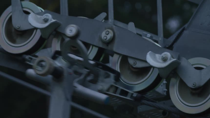A closeup of the wheels and metal parts on a sky lift station