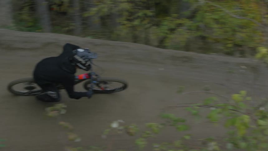 Person performing mountain bike movements through the forest