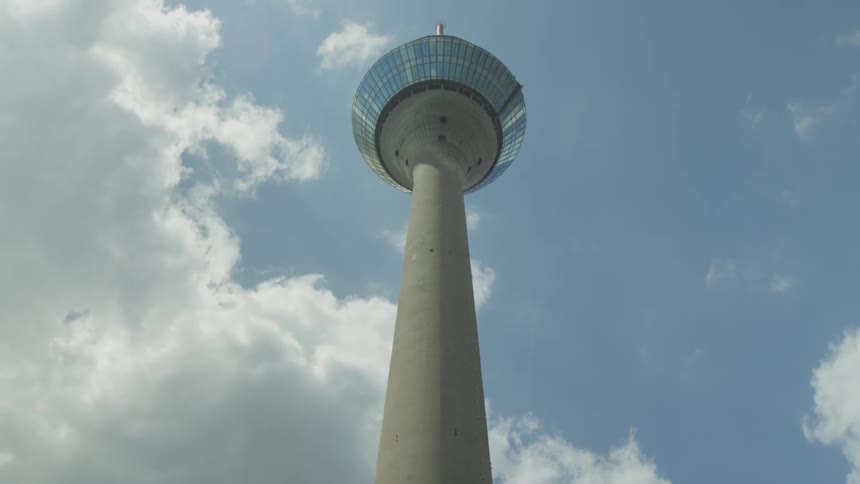 A concrete tower with mirrored windows during the day